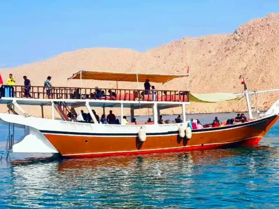 Traditional dhow on the Musandam Dibba tour, anchored below the mountains